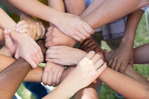 Group of volunteers putting hands together during a community based fundraiser
