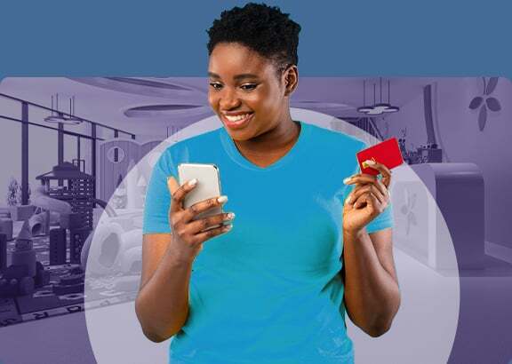 Smiling woman easily processing a payment with a smartphone and credit card, representing simplified payment processing.