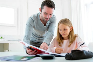 Dad with daughter looking over notebook