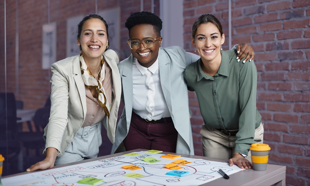 Team of three business people reviewing an operations plan with colorful sticky notes.