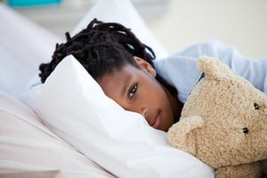 Young Boy in Hospital  hugging his teddy bear