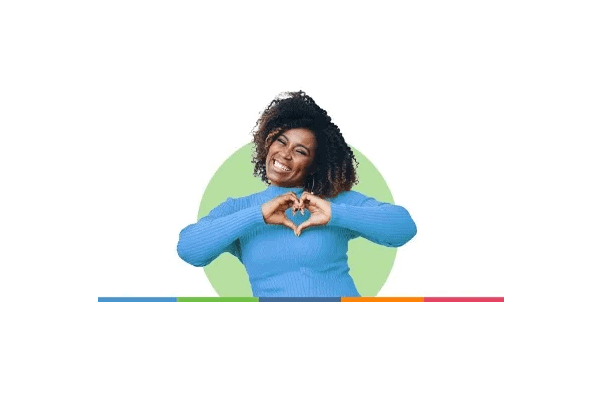 Smiling woman forms a heart shape with her hands, symbolizing care and connection.