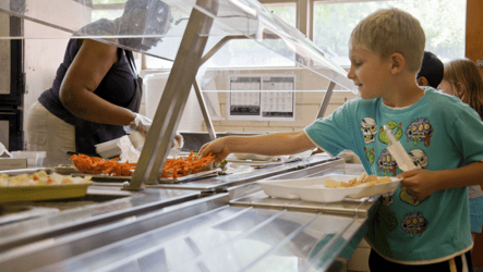Image of a student grabbing food from the school cafeteria